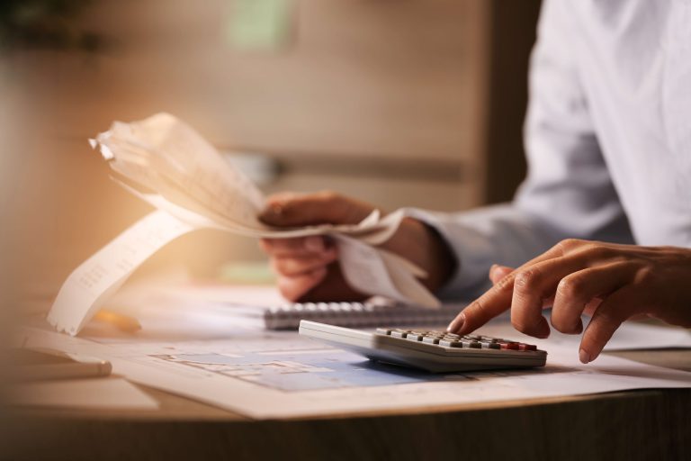 primer-plano-economista-que-usa-calculadora-mientras-revisa-facturas-impuestos-oficina (1)